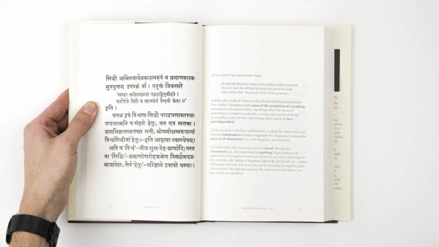 Interior spread of hard cover book showing sutra on left, text on right