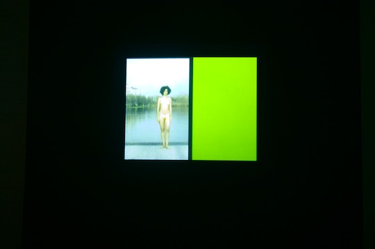 photo of video projecting woman in bikini next to a green rectangle of light