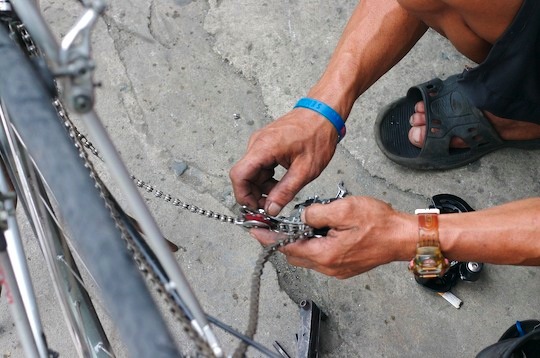 A mechanics hands replacing a bicycle deraileur