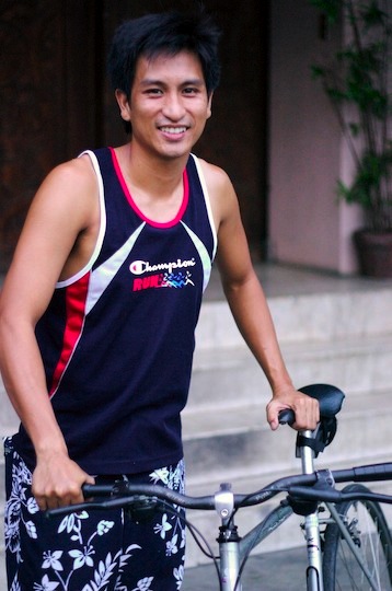 A Filipino man next to his bicycle