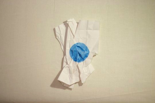 crumpled paper with blue dot