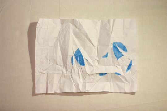 uncrumpled paper with blue fragments