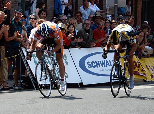 Two cyclists with their heads down sprint for the finish line