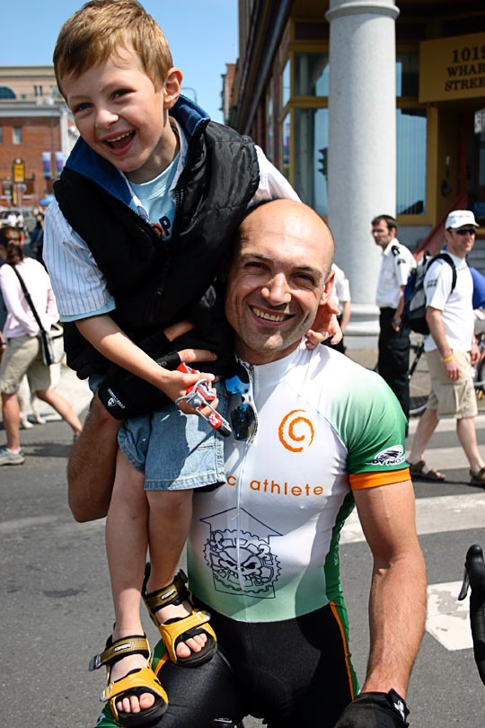 A cyclist standing with his bike and his son