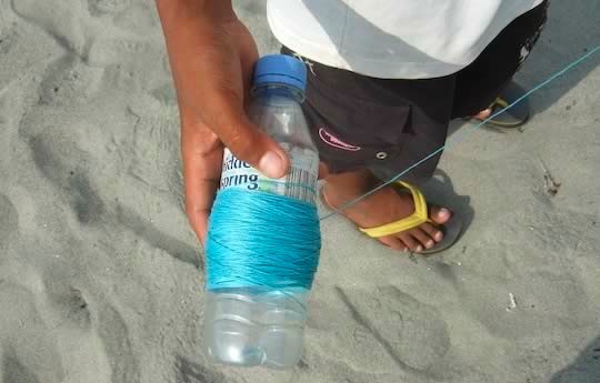 Kite string wound around a plastic bottle