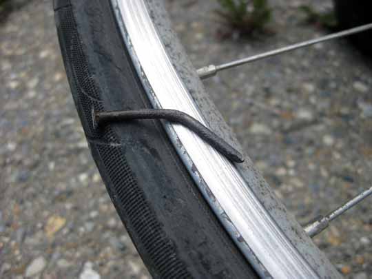 Bent nail resting on bicycle wheel