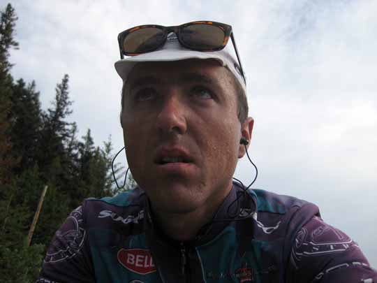 View of cyclist face while riding up hill, sweaty pained look