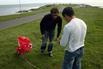 Two guys prepare a kite