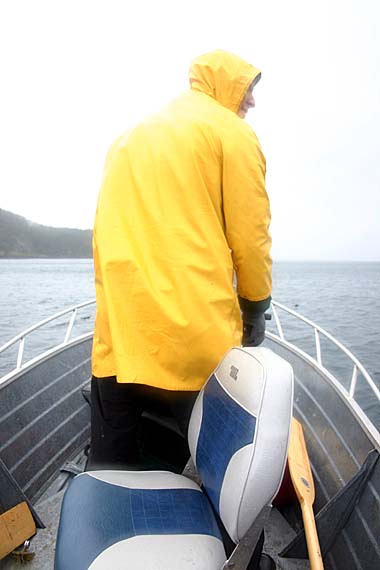 Man in yellow jacket standing in boat